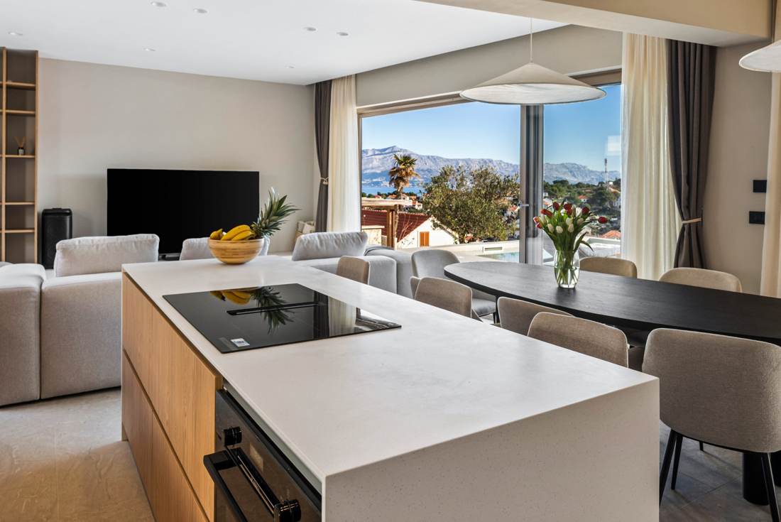 Open-plan kitchen island, living area and sea view