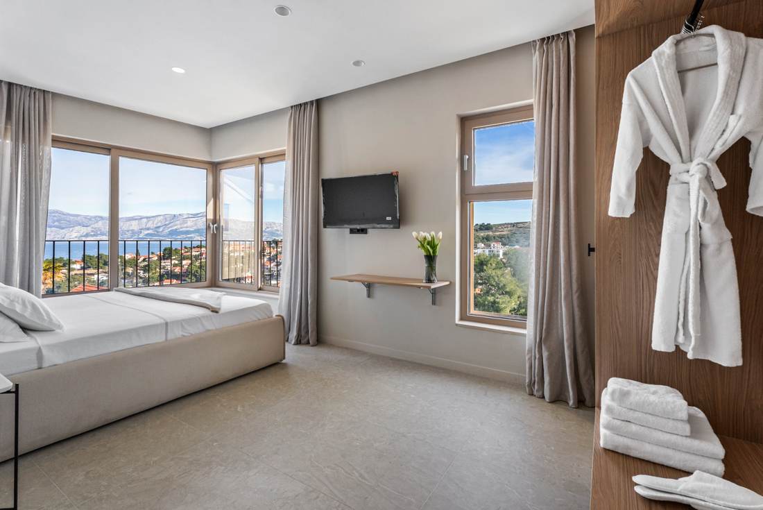 Bedroom with corner windows, bathrobe and towels