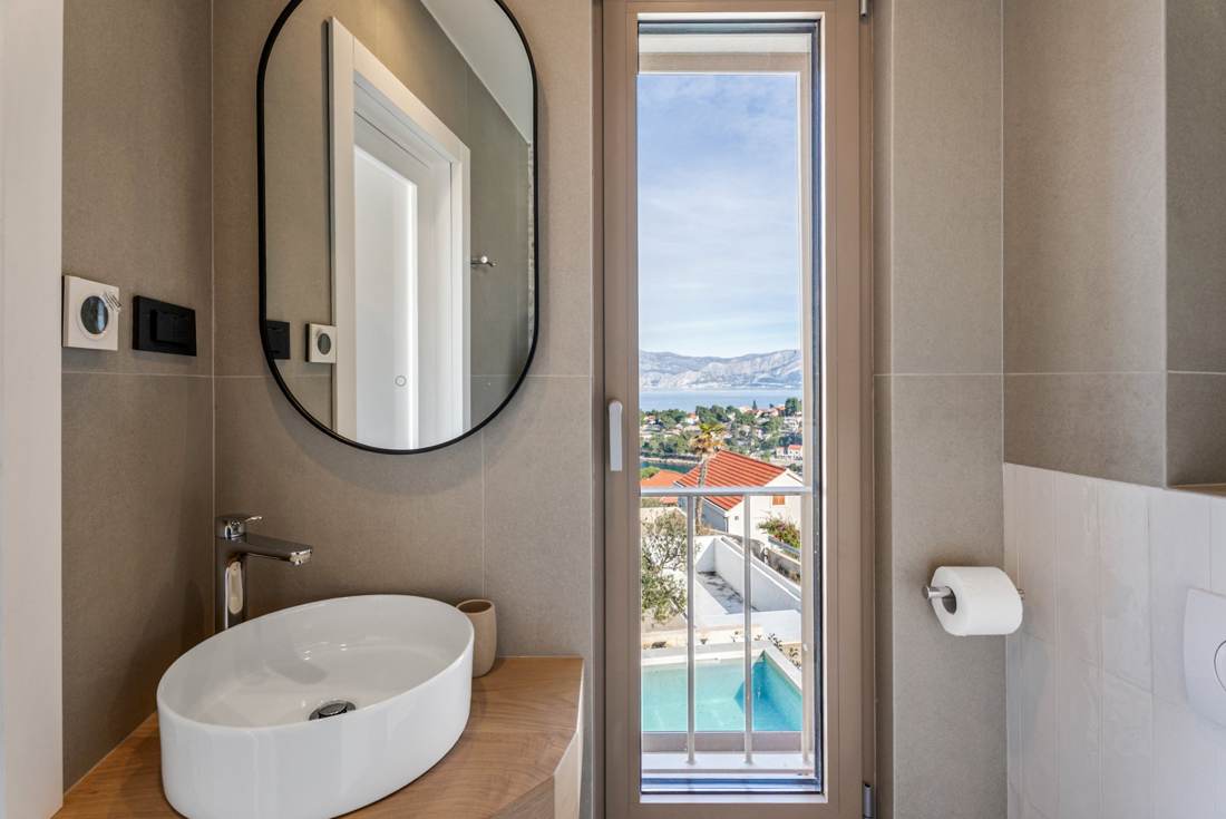 Bathroom with a view of the pool and sea