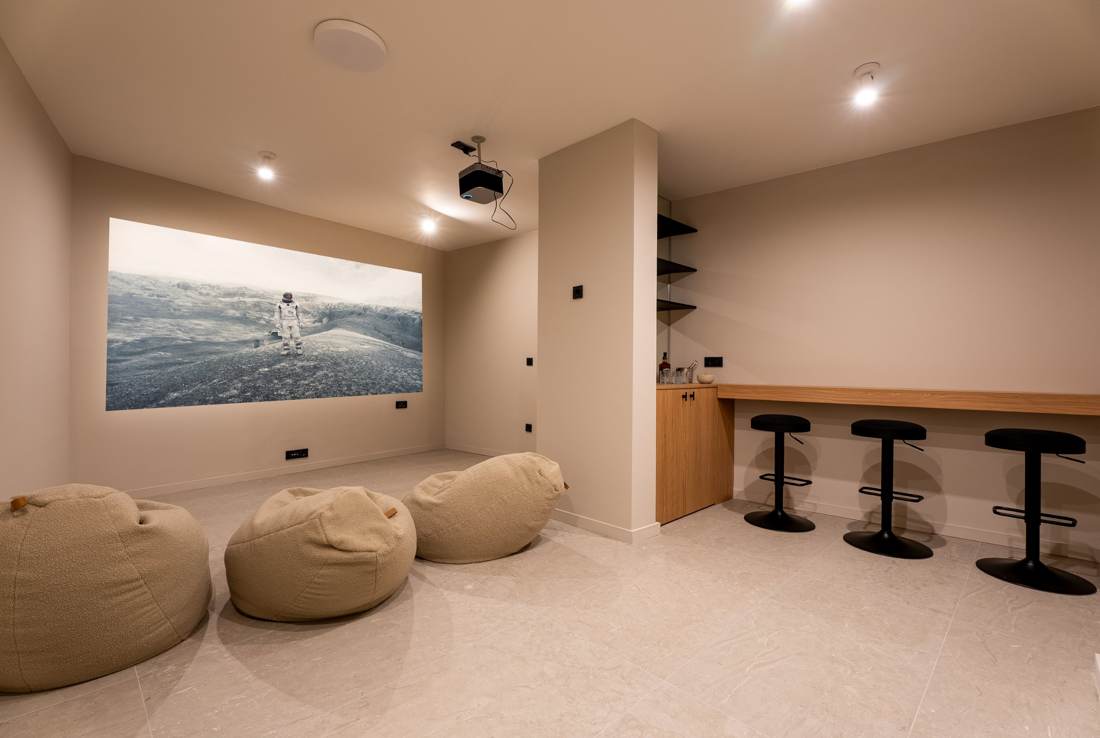 Home cinema room with projector, bean bags and bar